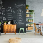 Dining room with chalkboard wall wooden chest and kitchen cart